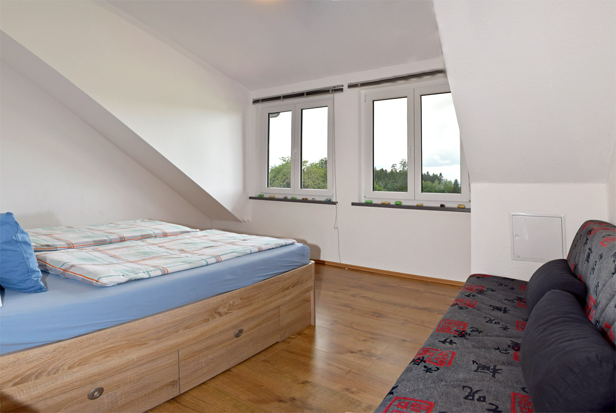 Schlafzimmer mit Doppelbett und Sofa
